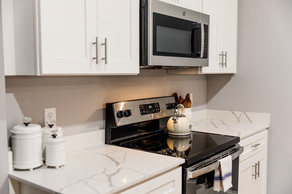 a kitchen with white cabinets and a black stove