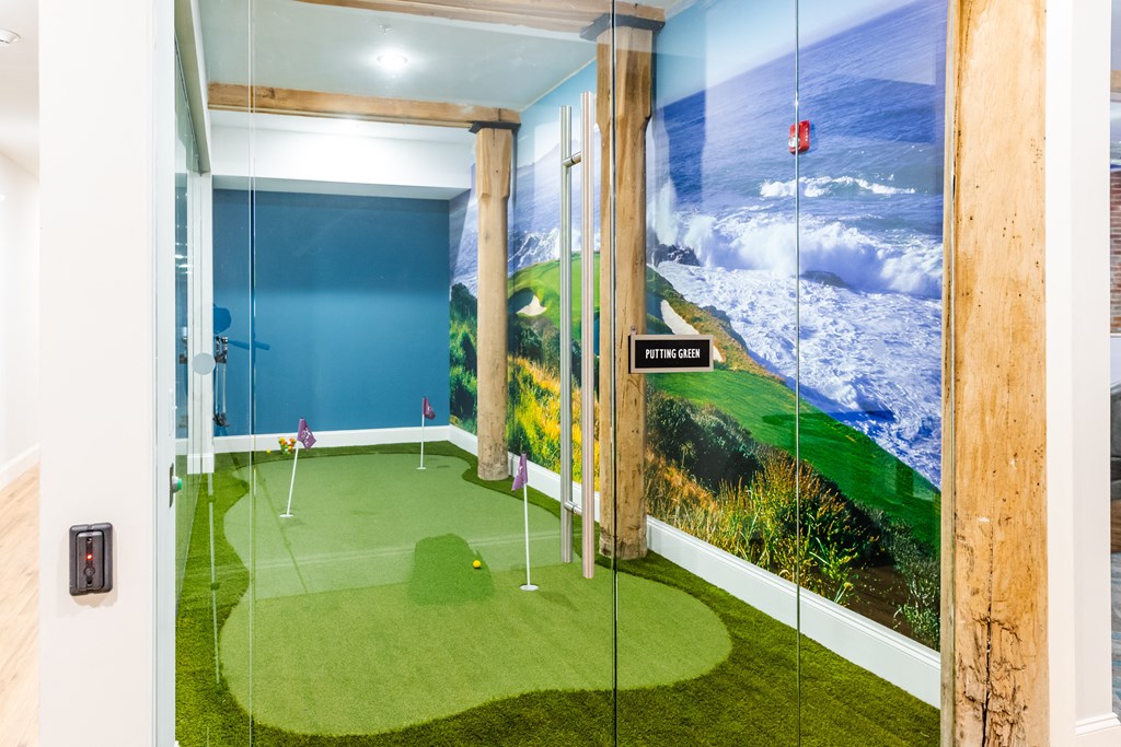 a golf simulator in a room with a view of the ocean