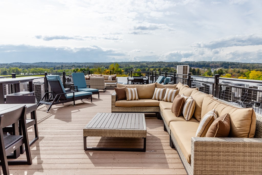 a rooftop deck with couches and chairs and a table