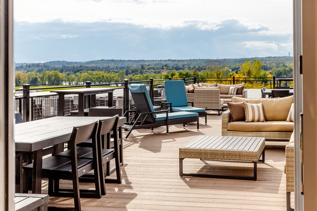 a large deck with chairs and tables overlooking a lake