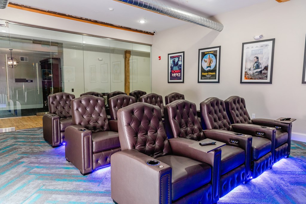 a room with a row of leather chairs and a blue carpet