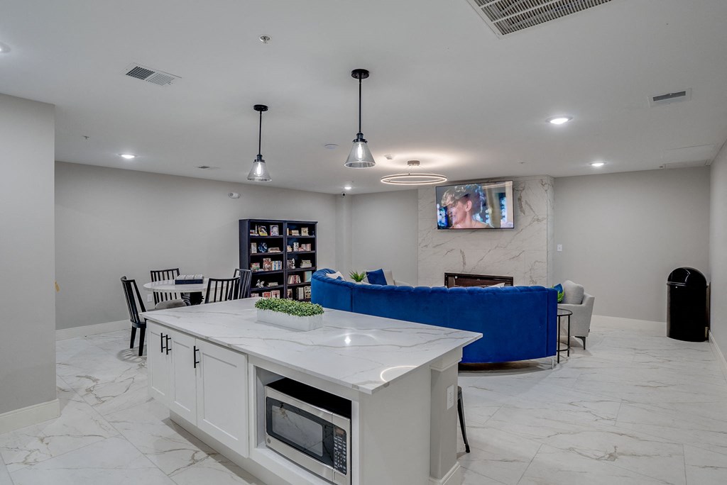 the living room has a large kitchen island and a blue couch