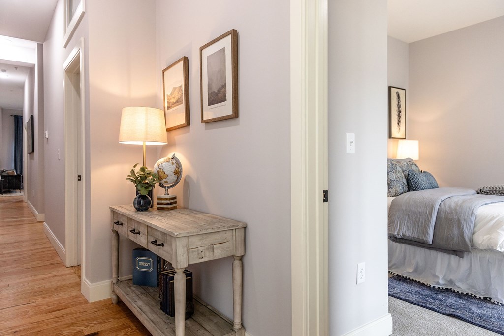 A bedroom with a bed, nightstand, and lamp.