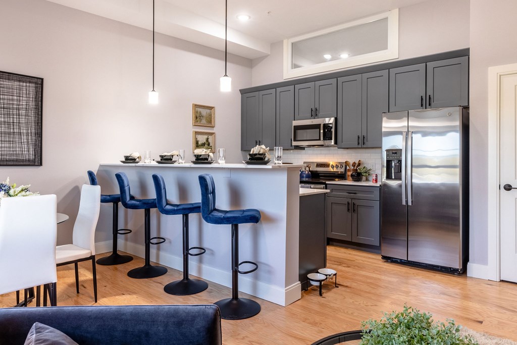 A kitchen with a bar area and chairs.