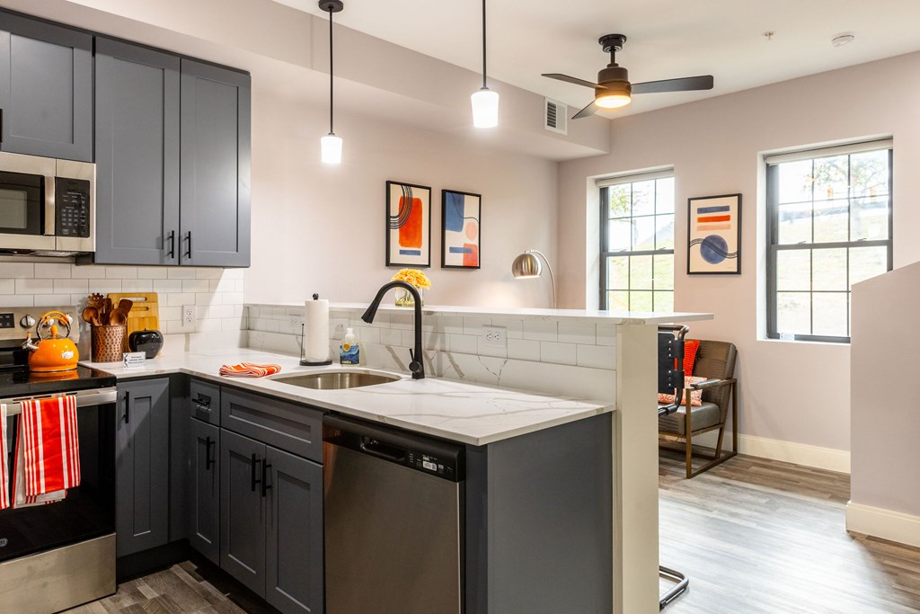 A kitchen with a black counter top and a white sink.