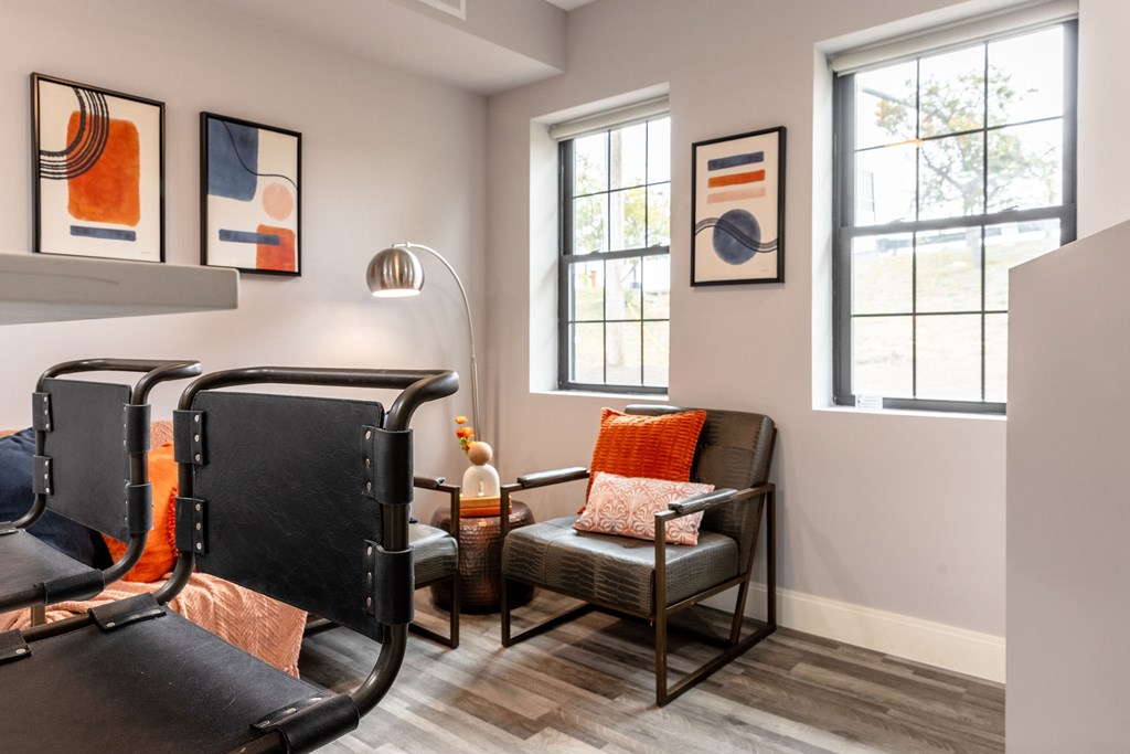 A living room with a black chair and a grey couch.