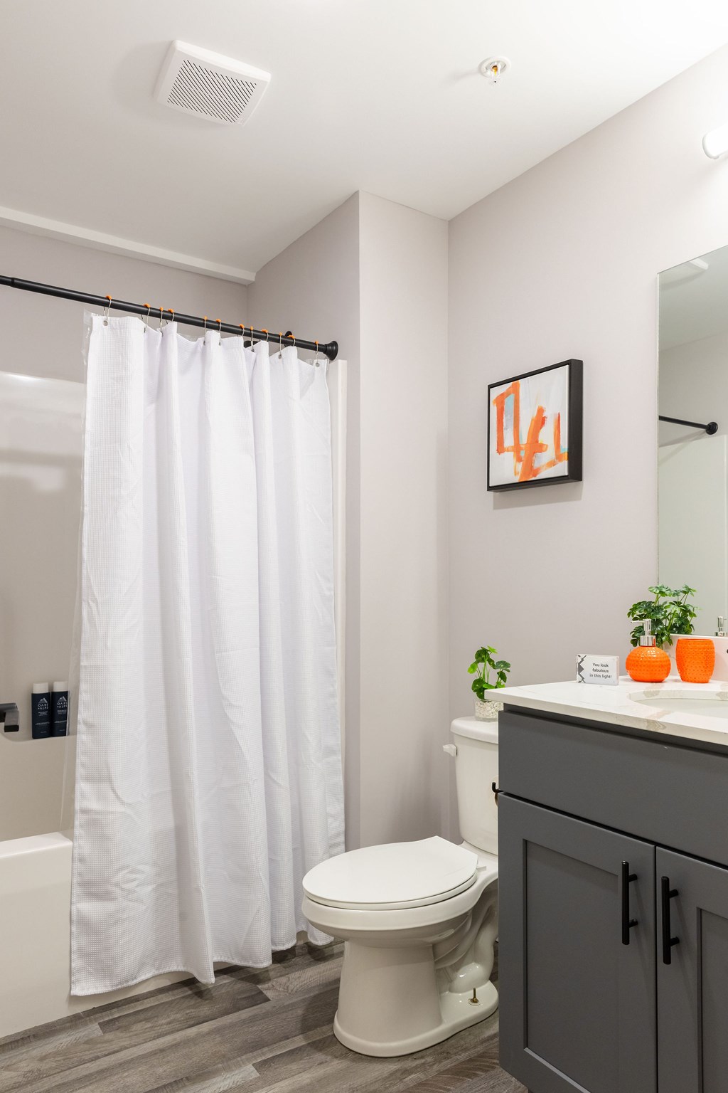 A bathroom with a toilet, sink, and shower curtain.