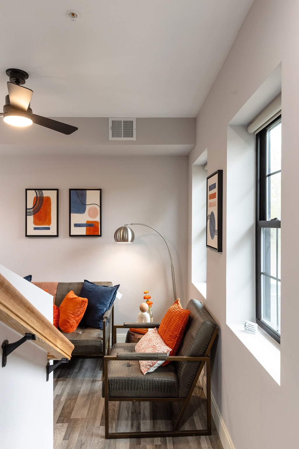 A living room with a couch, a table, and a ceiling fan.
