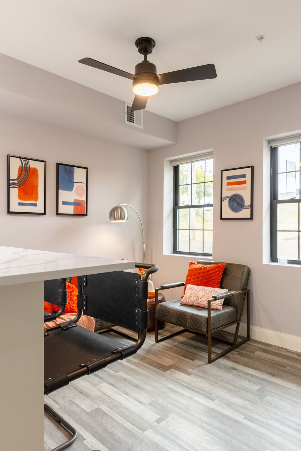 A living room with a ceiling fan and a chair.