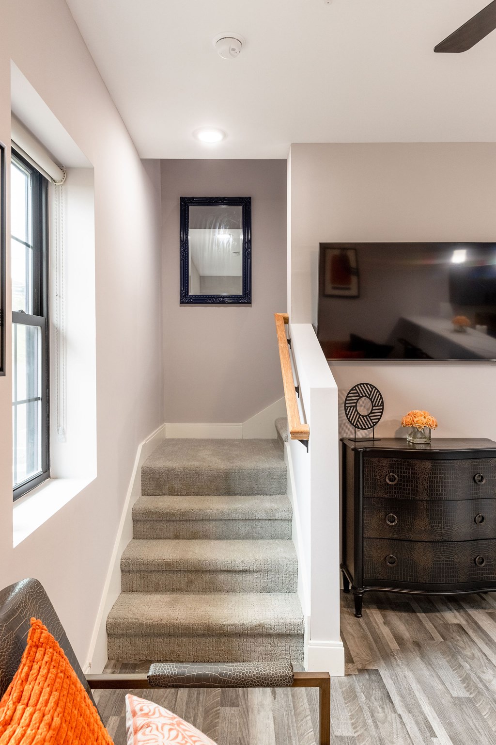 A staircase with a grey carpeted runner and wooden banister.