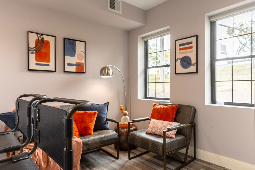 A living room with a grey couch and a black chair.