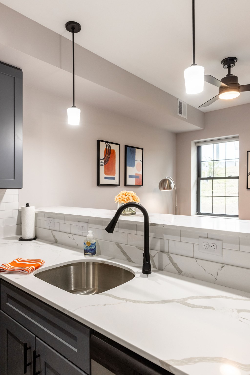 A modern kitchen with a black faucet and a white sink.