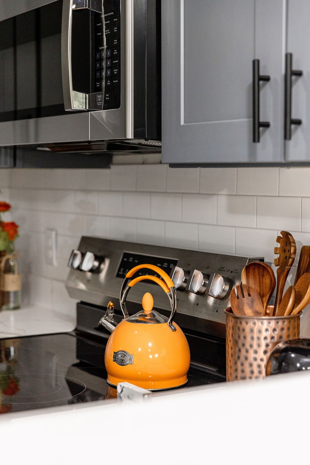 A modern kitchen with a stove top and a kettle on it.