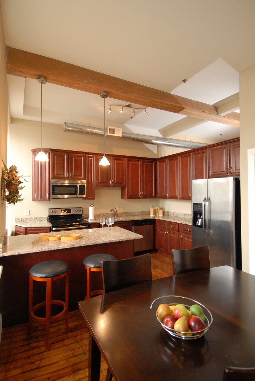 a large kitchen with stainless steel appliances and wooden cabinets
