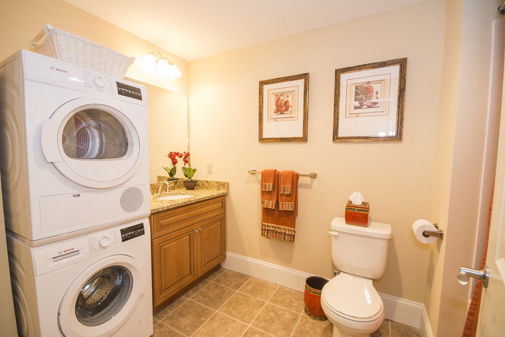 a bathroom with a washing machine in it and a toilet
