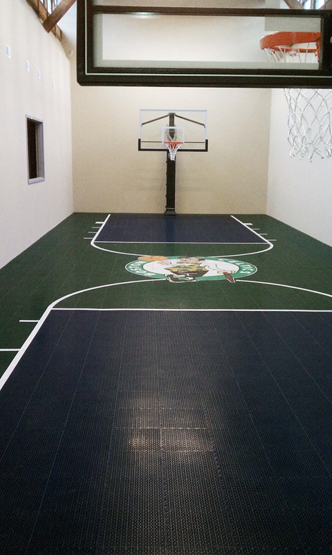 a basketball court in a gym with a basketball hoop in the background