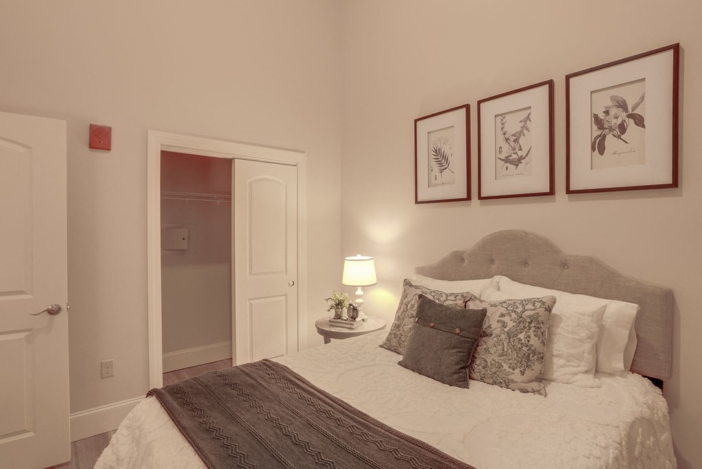 a bedroom with a bed and some pictures on the wall