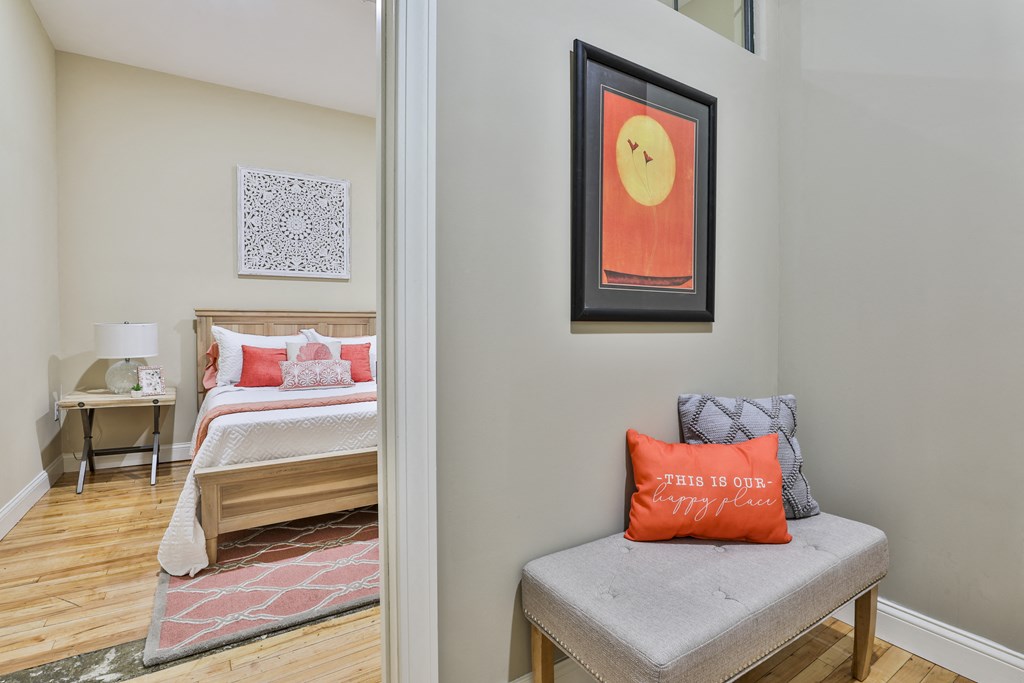 a bedroom with a bed and a chair with a pillow on it