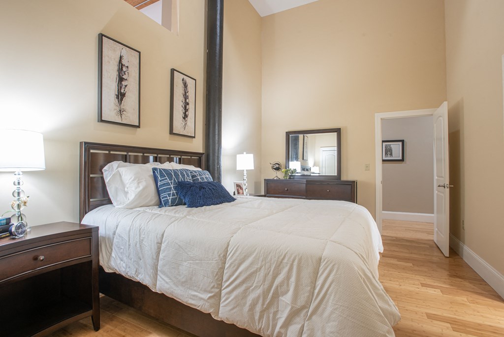a bedroom with a large bed and wooden floors