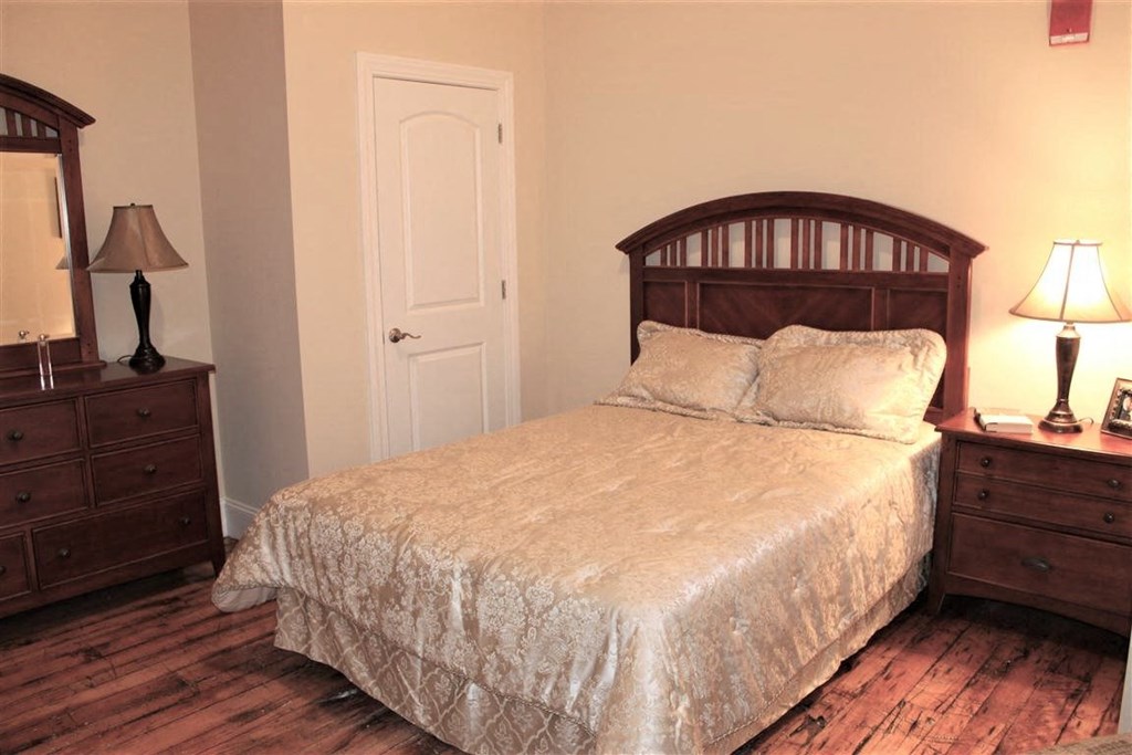 a bedroom with a bed and two dressers