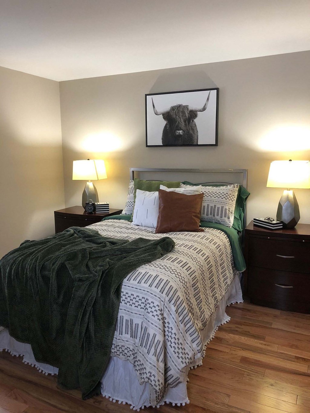 a bedroom with a bed and a picture of a bull