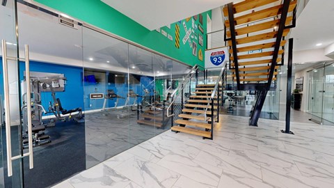 A gym with a staircase and a glass wall.