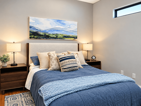 A bedroom with a large bed and a painting on the wall.