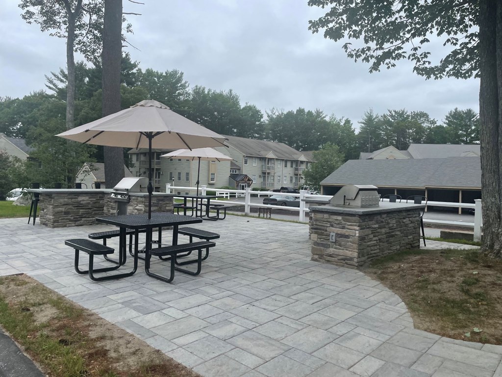 a patio with an umbrella and picnic table