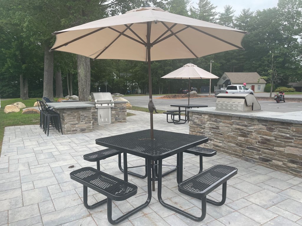 a patio with a table and chairs with an umbrella
