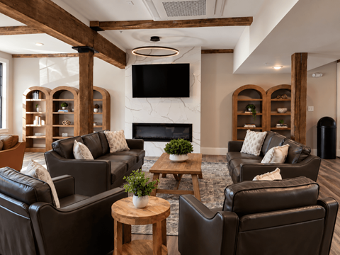 A living room with brown leather chairs and a fireplace.