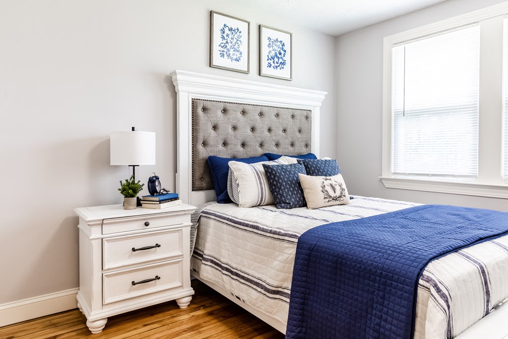 a bedroom with a bed and two windows