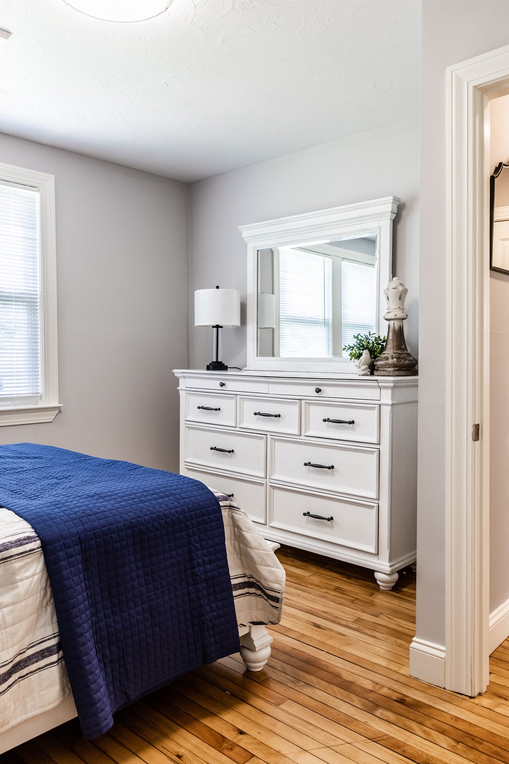 a bedroom with a large white dresser with a mirror on top of it