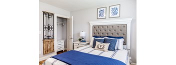 a bedroom with a bed with blue and white bedding and a nightstand with a lamp