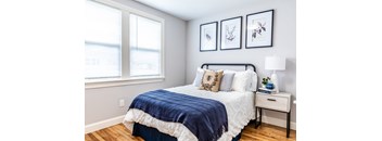 a bedroom with a bed and two windows