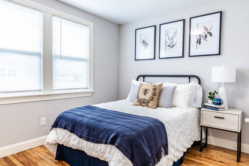 a bedroom with a bed and two windows