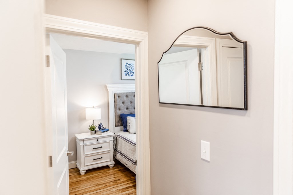 a bedroom with a bed and a mirror on the wall