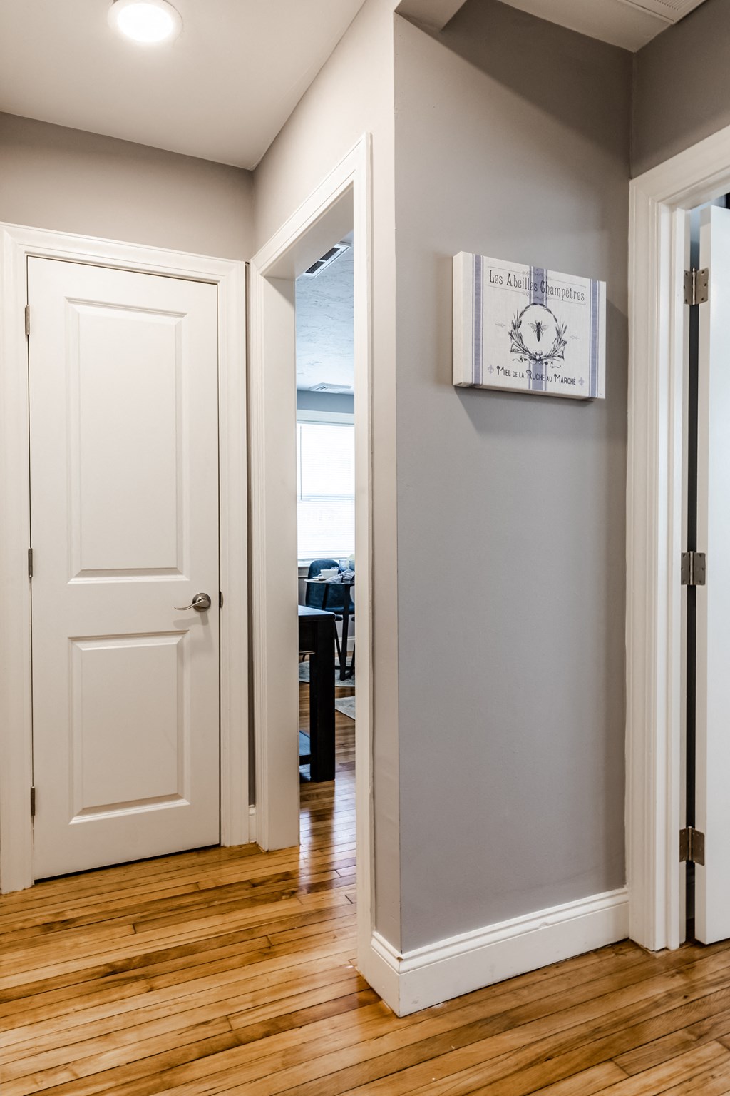 a view of a hallway with a door open and a clock on the wall
