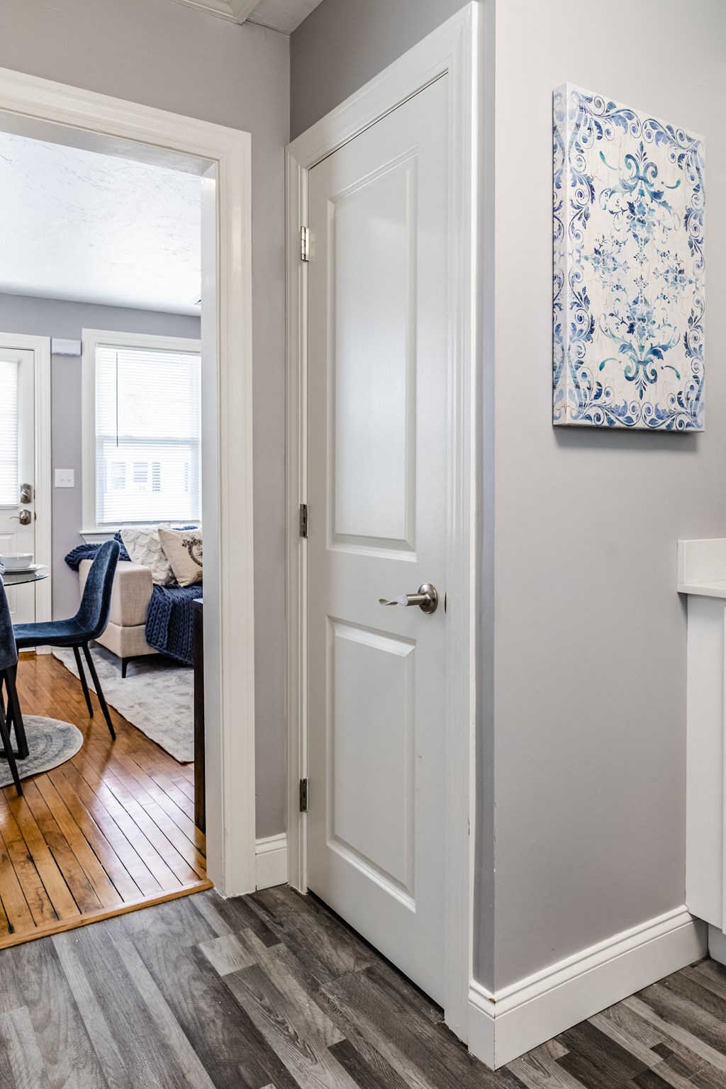 a door leading into a living room with a dining room in the background