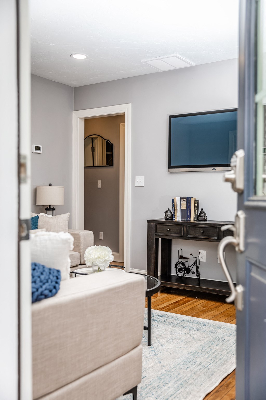 a living room with a couch and chair and a tv on the wall