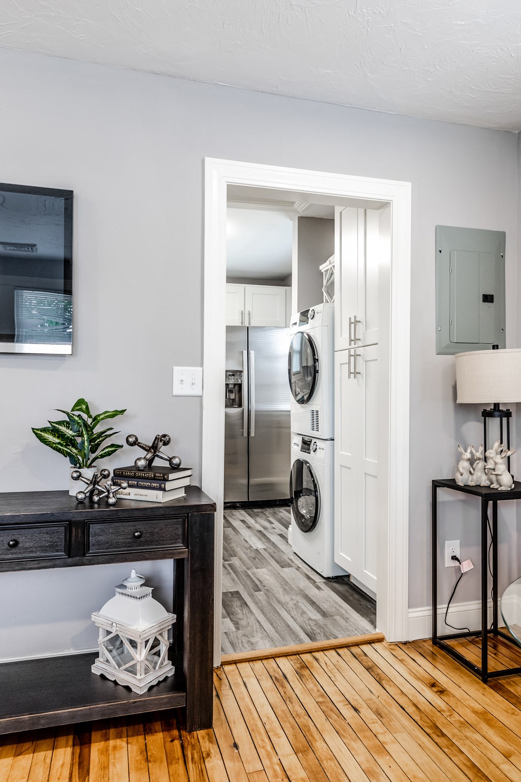 a living room with a door that leads to a kitchen with a washer and dryer