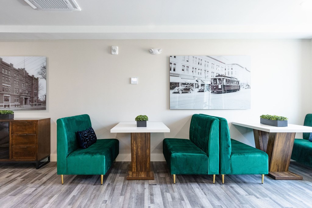A room with a green chair and a table with a plant on it.