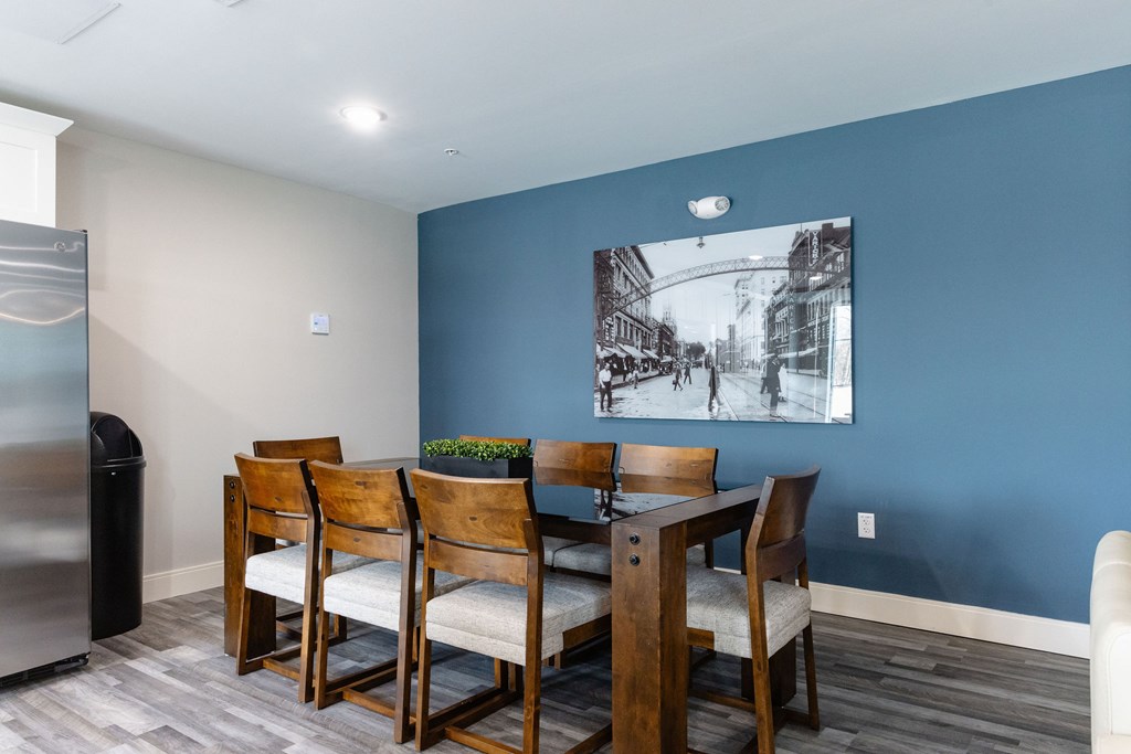 A dining room with a wooden table and chairs.