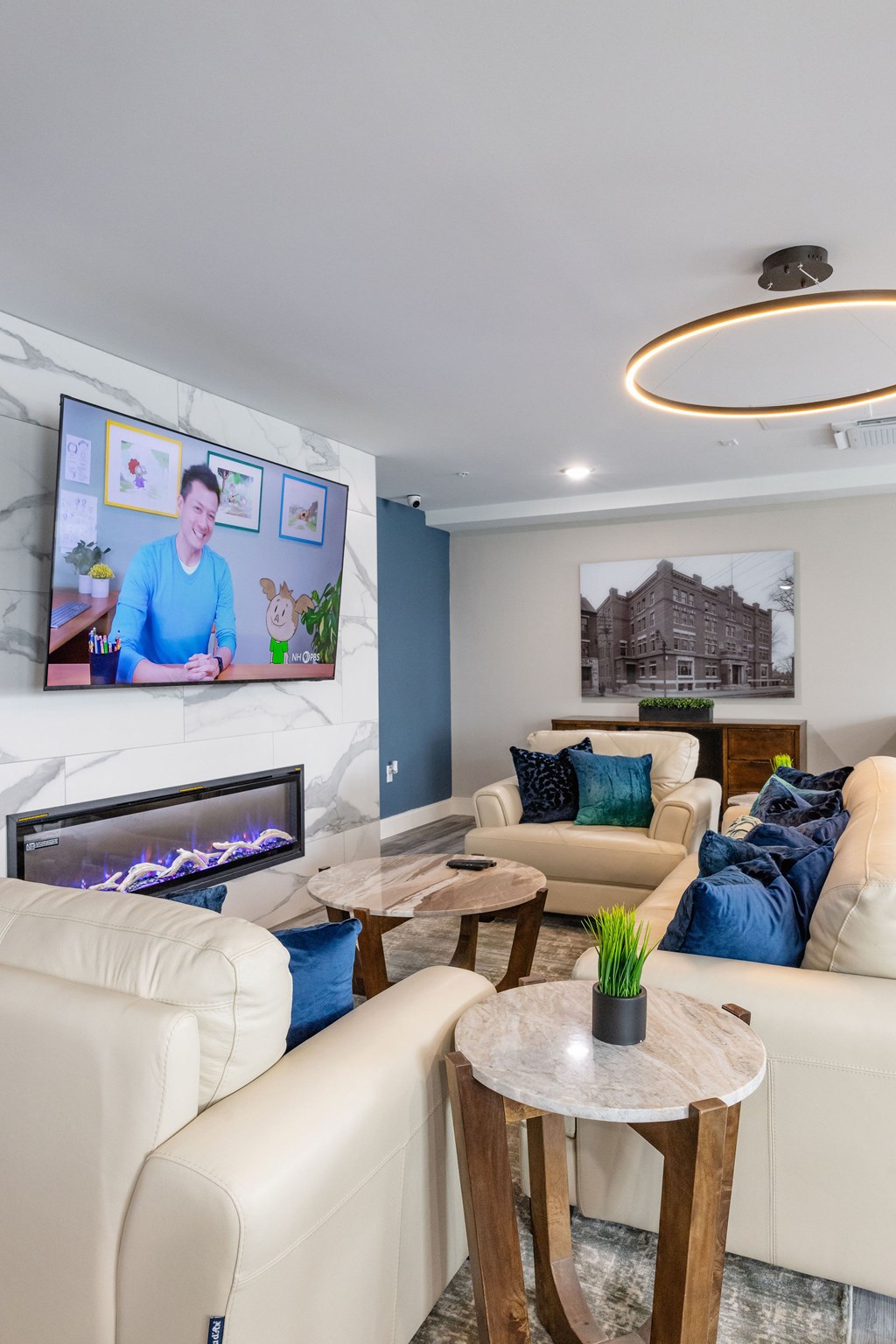 A living room with a fireplace and a television on the wall.