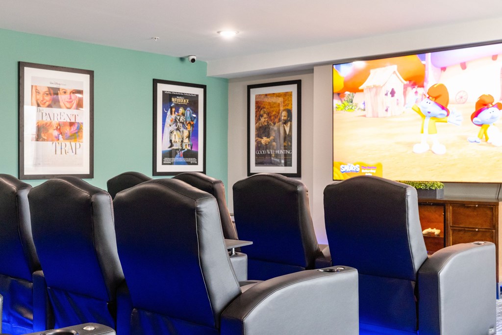 A row of blue chairs are in front of a wall with posters on it.