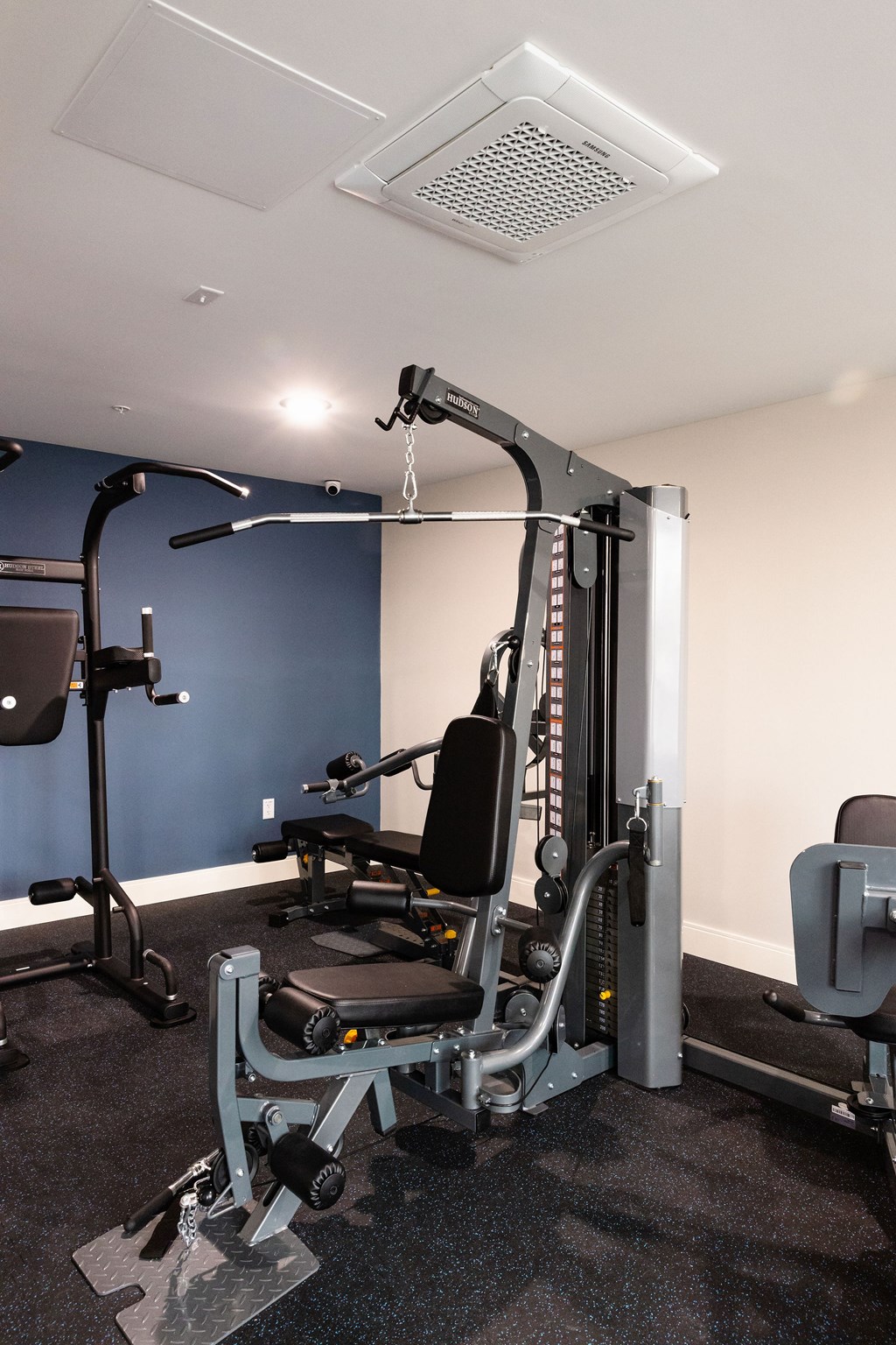 A gym with a weight machine and a bench.