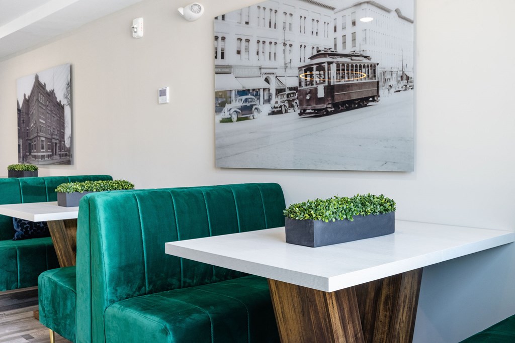 A white table with a green couch and a plant on it.