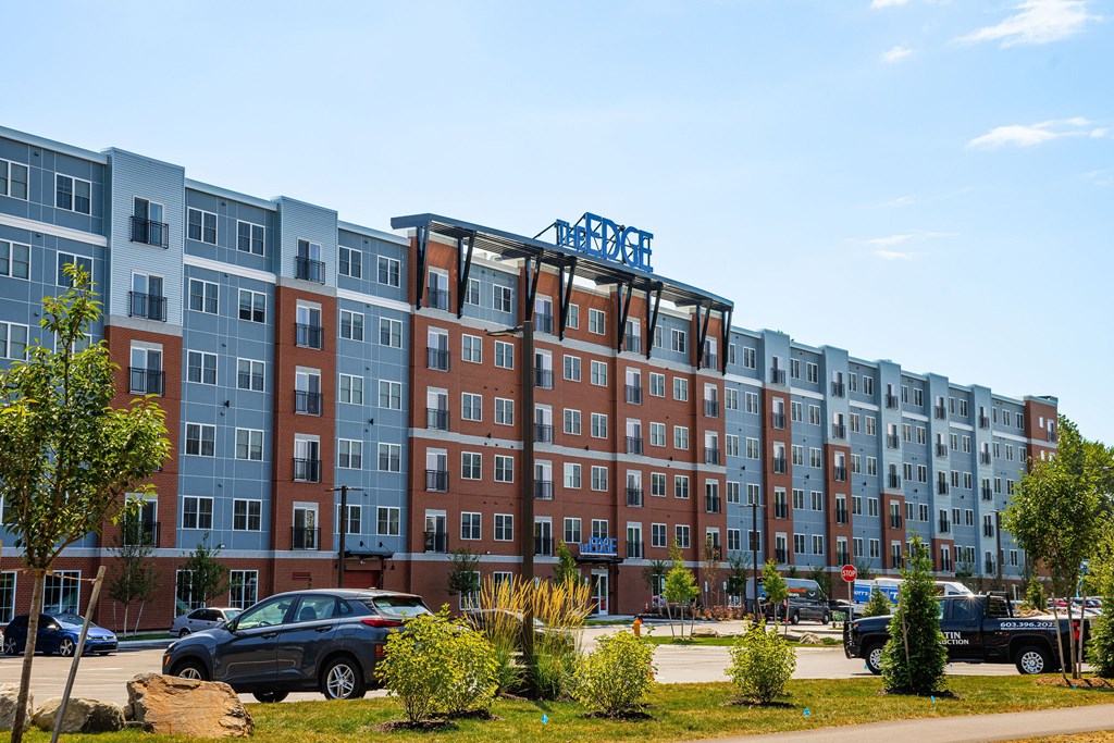 A large apartment complex with a blue sign on the side.
