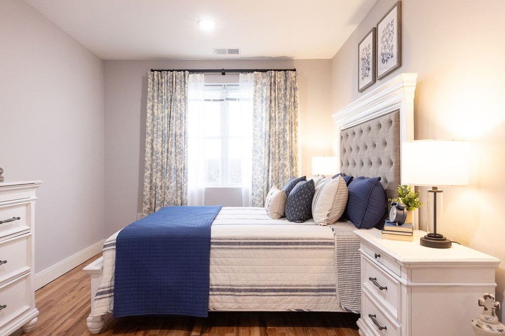 A bedroom with a white bed and blue bedspread.