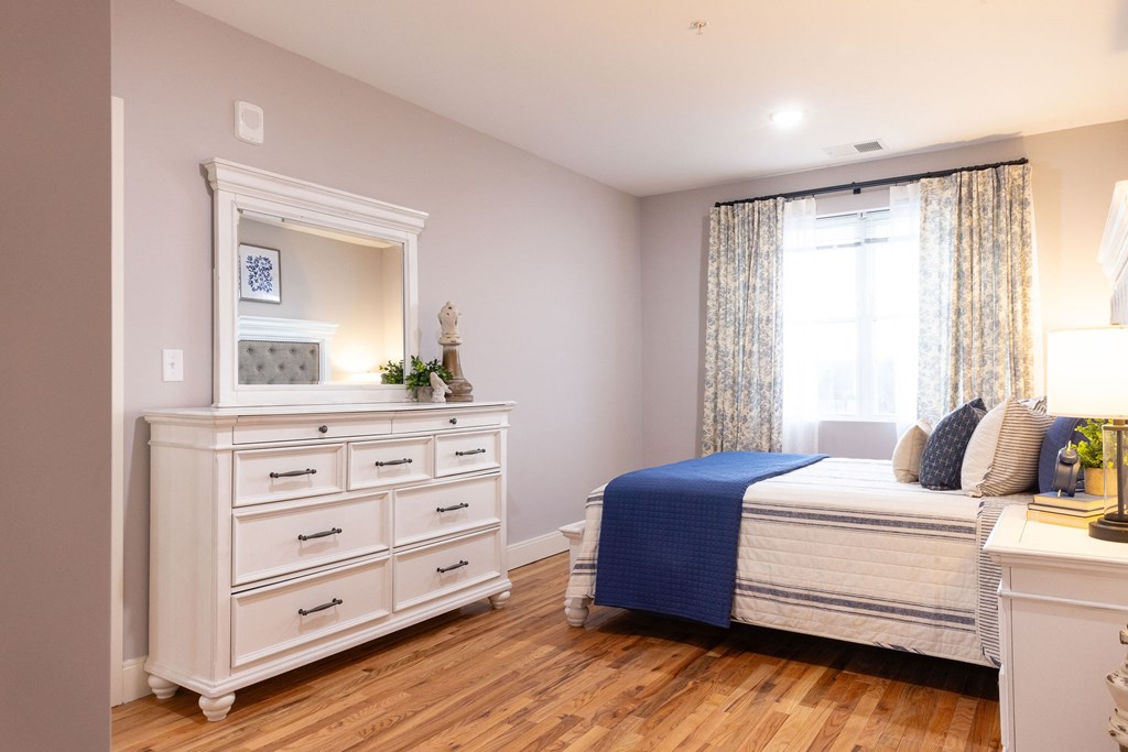 A bedroom with a bed, dresser, and nightstand.