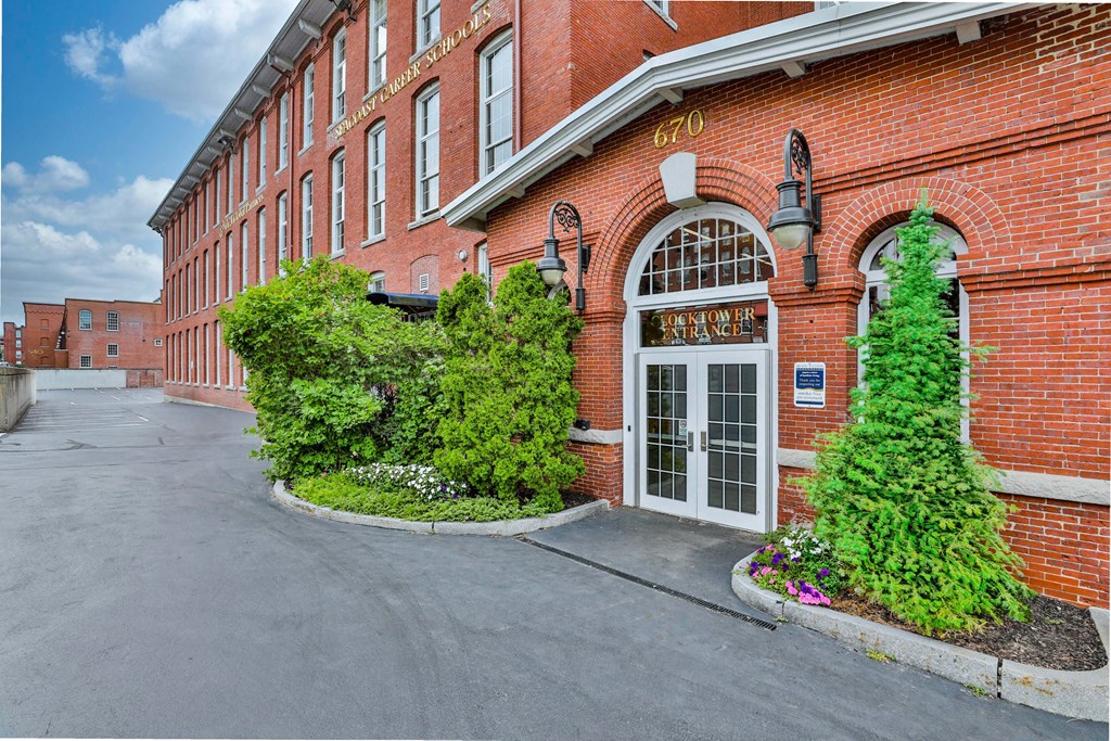 the facade of a red brick building with green plants